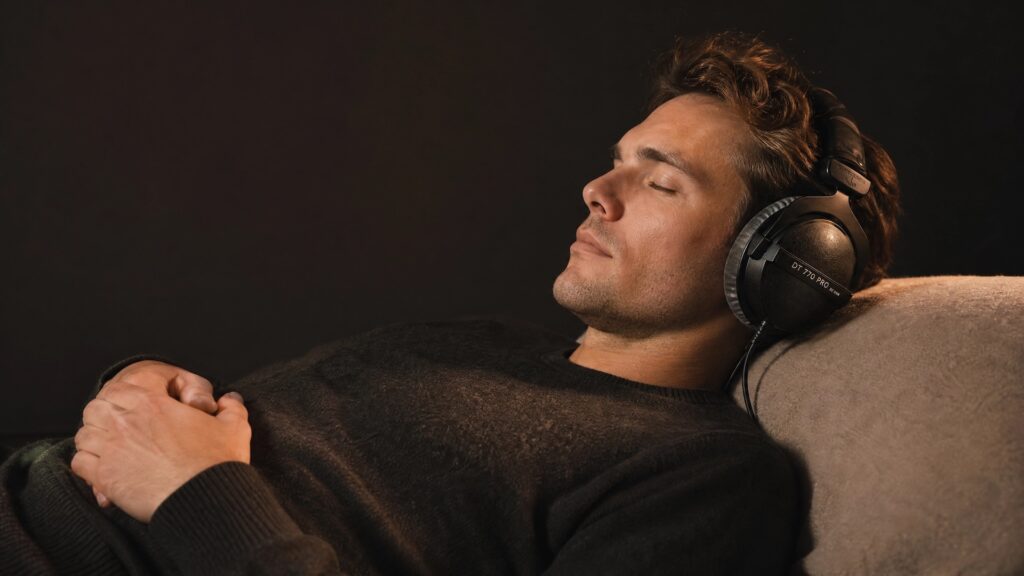 Person lying down with headphones listening to 528 Hz music in a relaxed position